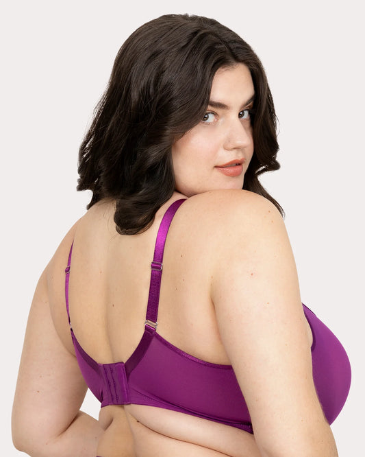 Woman wearing a purple bra against a plain background