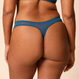 Woman wearing a blue bikini against a beige background