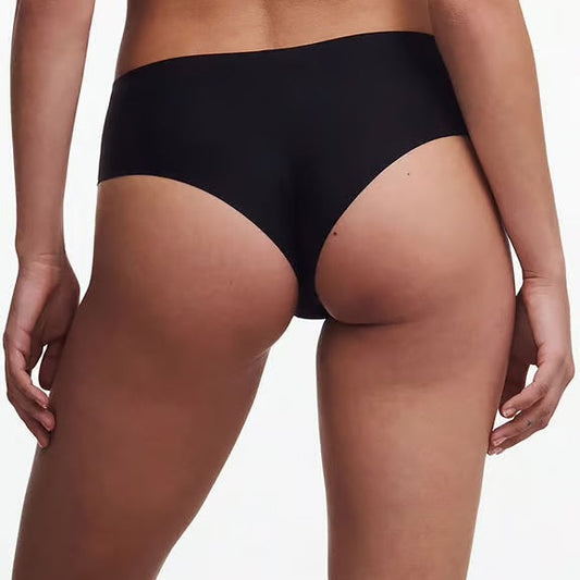 Person wearing black underwear on a plain background