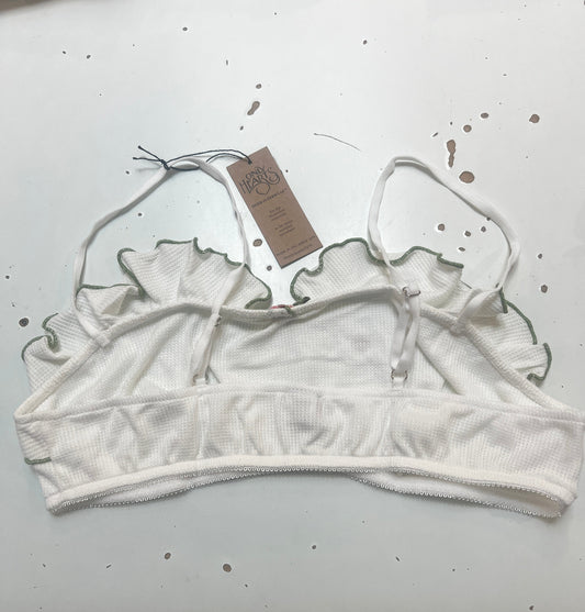 White lace bralette with a tag on a white background