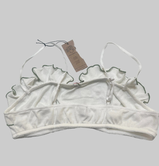 White lace bralette with a tag on a white background
