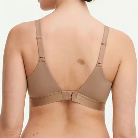 Woman wearing a beige bra on a white background