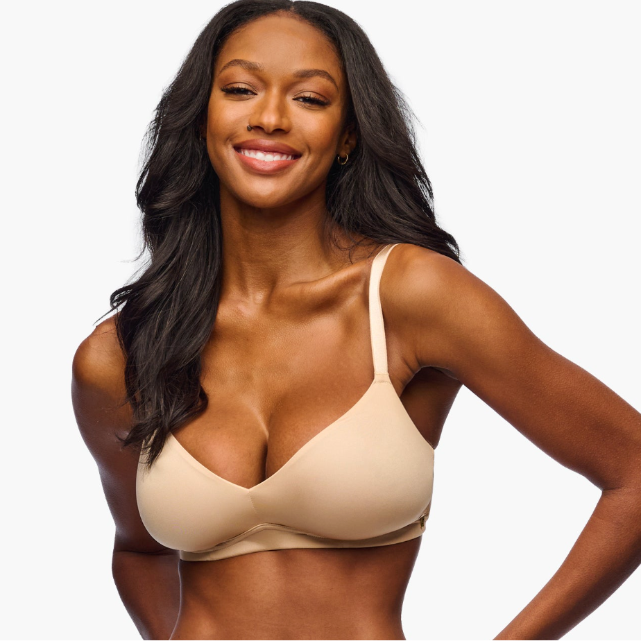 Woman wearing a beige bralette on a white background