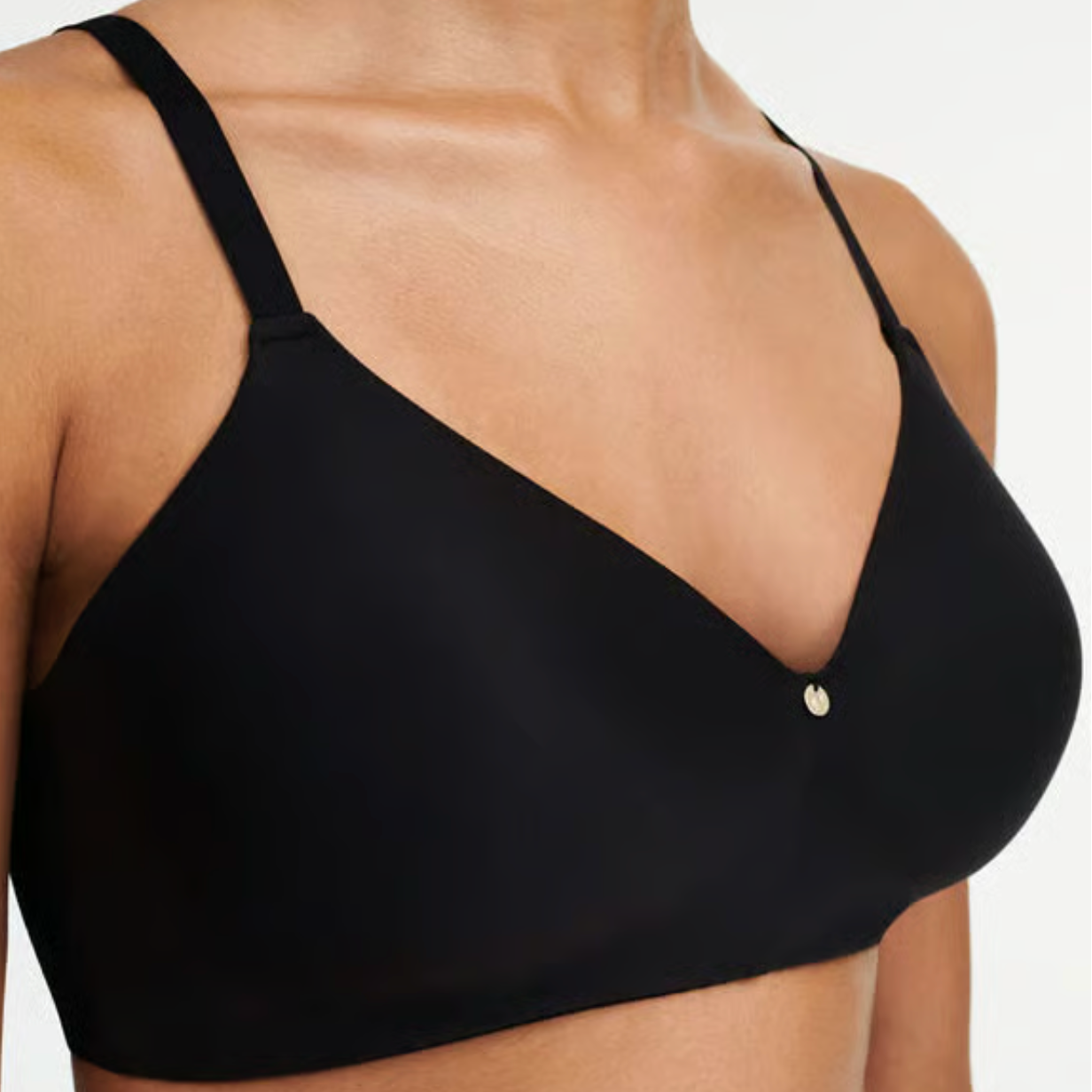 Black bra worn by a person on a plain background