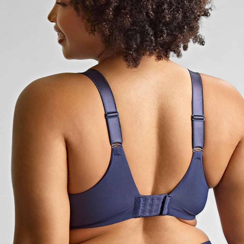 Woman wearing a blue bra against a plain background