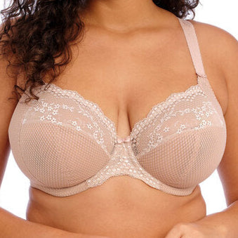 Woman wearing a beige bra with lace details on a white background