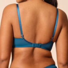 Woman wearing a blue bikini against a beige background