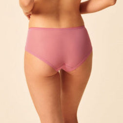 Woman wearing a pink bikini set on a beige background