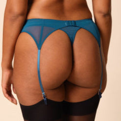 Woman wearing a blue lingerie set on a beige background