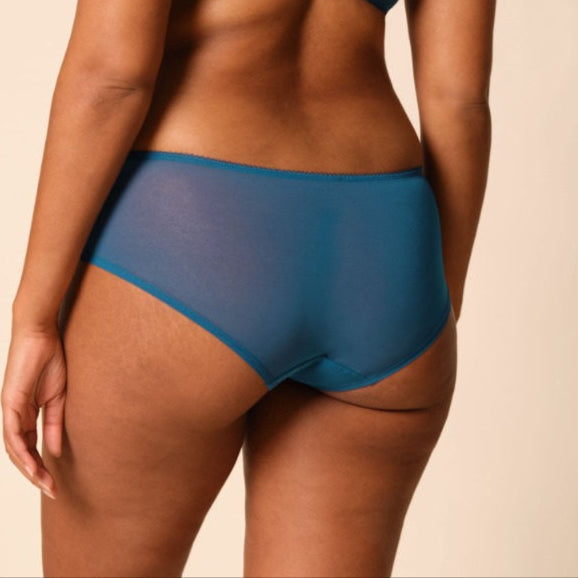 Woman wearing a blue bikini set on a beige background