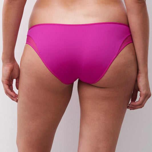 Person wearing bright pink bikini bottoms on a plain background