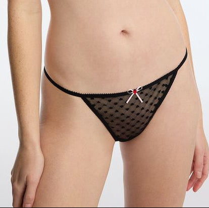 Black polka dot lingerie with a red heart design on a plain background