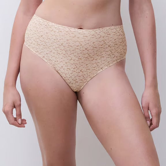 Beige lace underwear worn by a person on a plain background