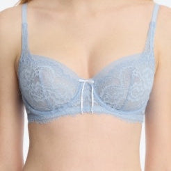 Woman wearing a light blue lace bra against a plain background