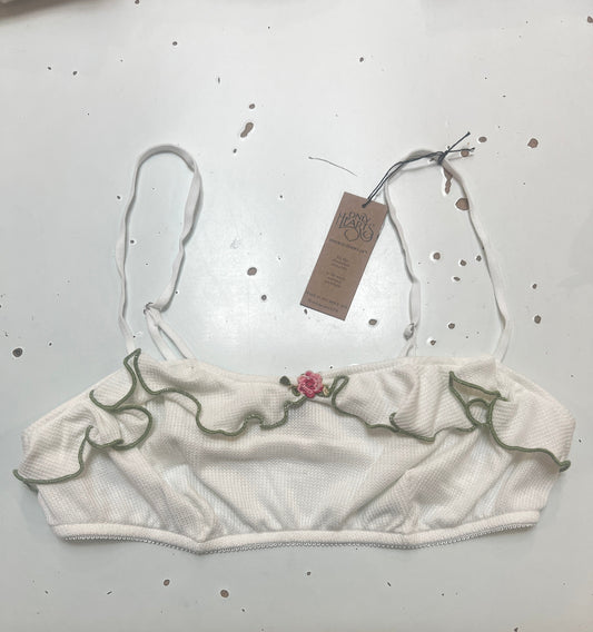 White baby romper with floral embroidery on a light gray background