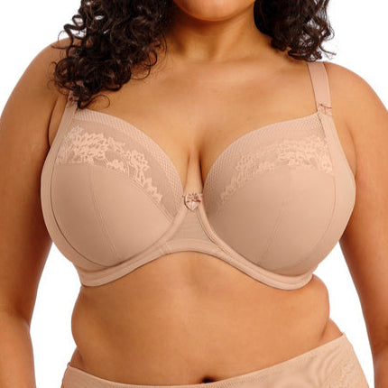 Woman wearing a beige bra and panties set on a white background