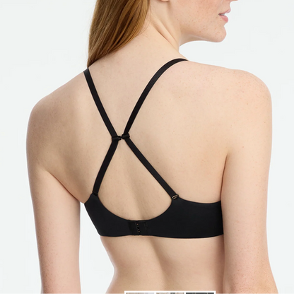 Woman wearing a black strappy bra on a white background