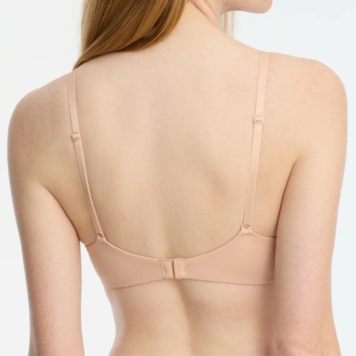 Woman wearing a beige bra on a white background