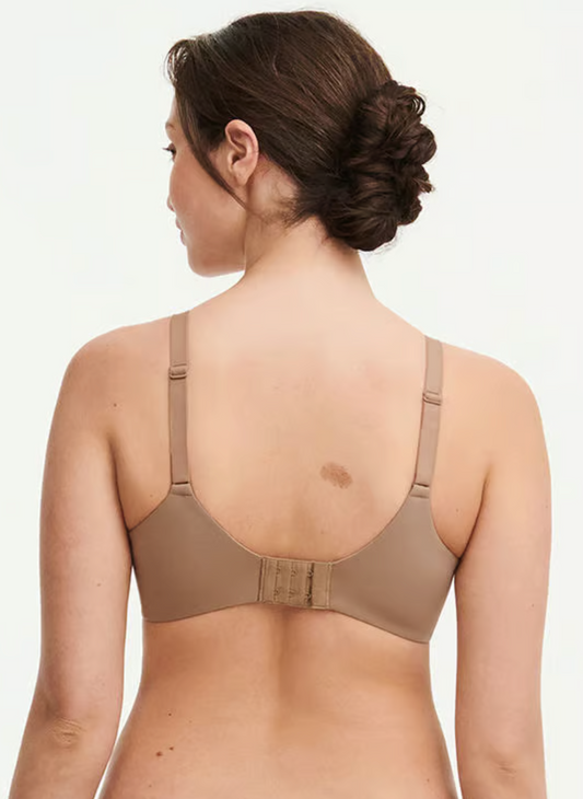 Woman wearing a beige bra on a plain background