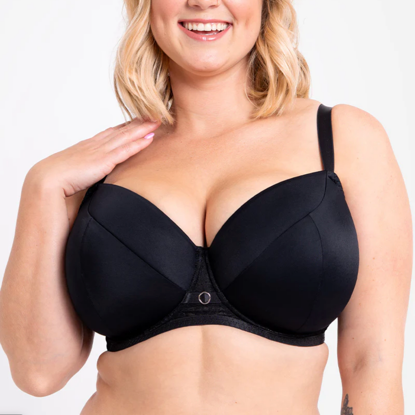 Woman wearing a black bra against a white background