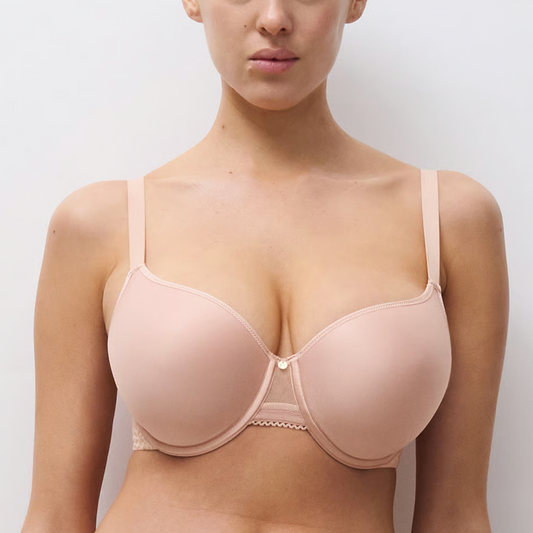Woman wearing a beige bra against a plain background