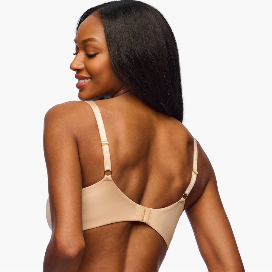 Woman wearing a beige bralette on a white background