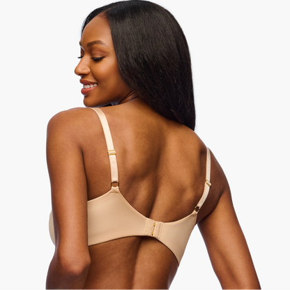 Woman wearing a beige bralette on a white background