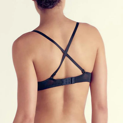 Person wearing a black strappy bikini on a plain background