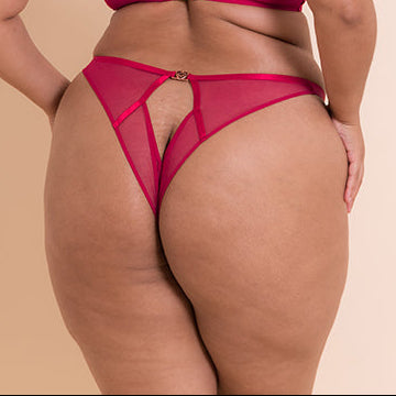 Woman wearing a pink lingerie set on a beige background