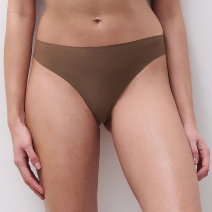 Person wearing brown underwear on a plain background